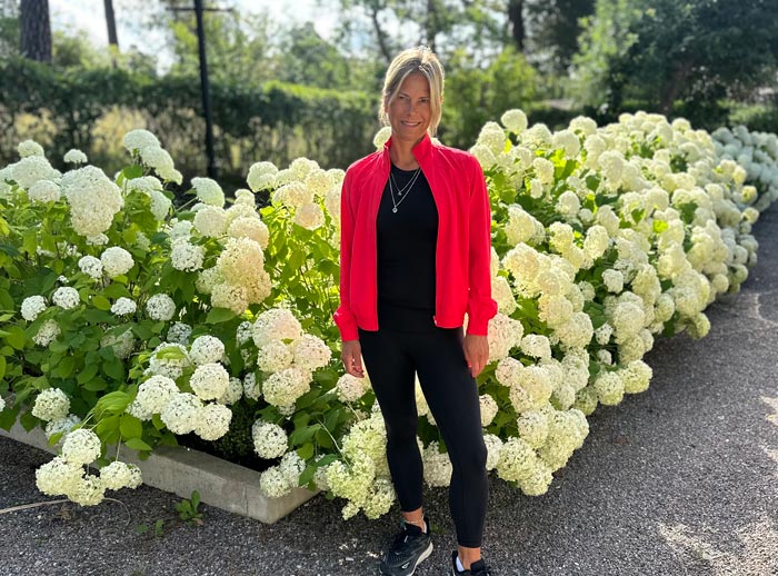 Charlotte med blommor i bakgrunden